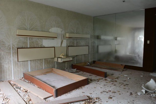 Empty bed frames against a hotel room wall