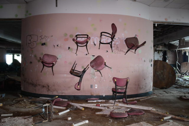Chairs jutting out of a pink wall