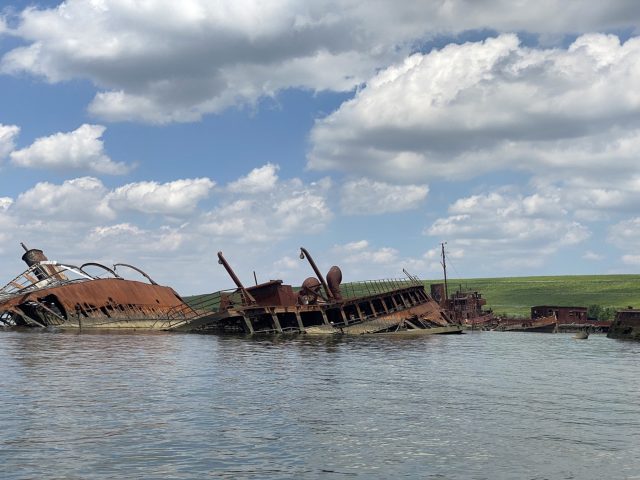 Two rusted ships sticking out of the water