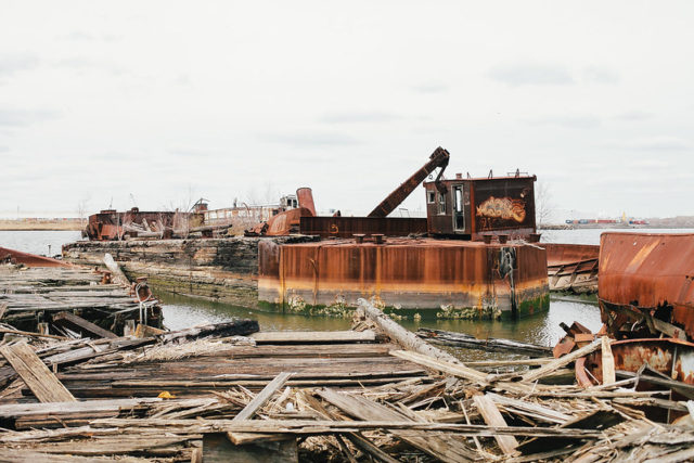 Broken wooden planks in front of a rusty boat