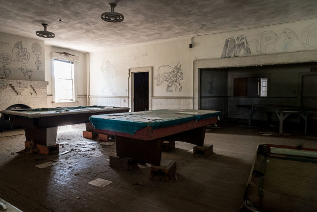 Two pool tables in a dark room