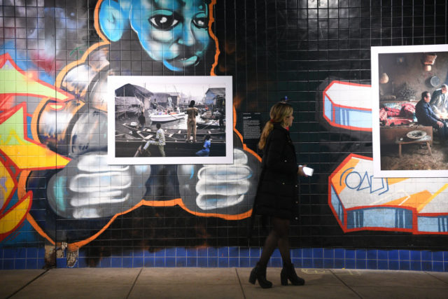 Woman walking by a photo exhibit