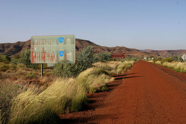 Faded road sign along a dirt road