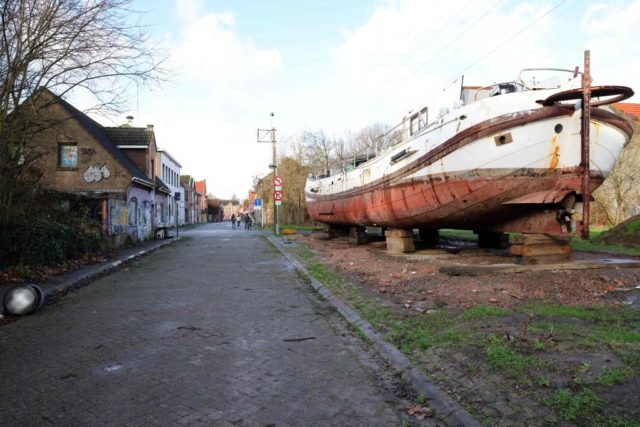 Rusty boat along a street in Doel