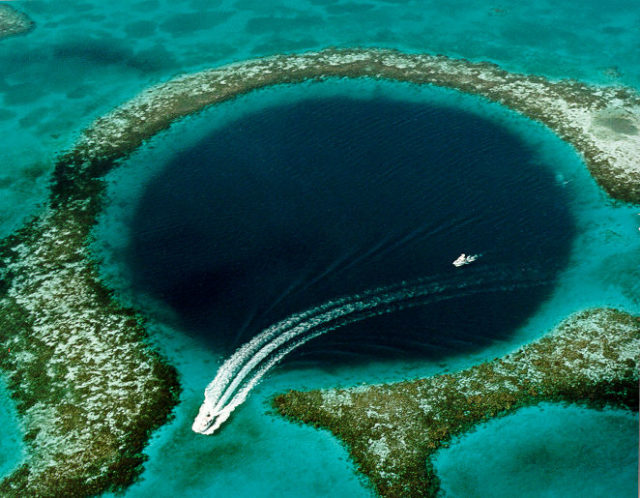 Aerial view of a boat leaving the area of the Great Blue Hole