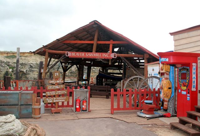 Exterior of a sawmill with modern appliances just outside the fence
