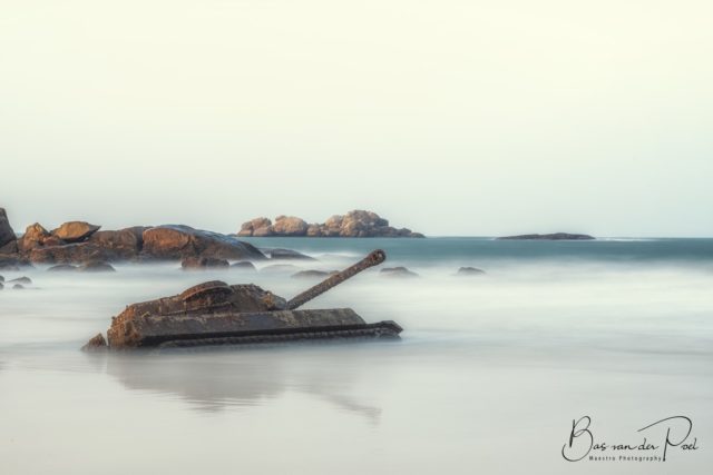 An old tank stuck in the sand at a beach