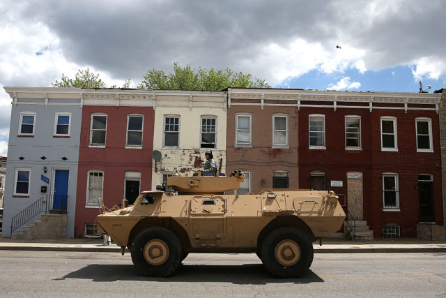 Armored vehicle parked in front of a row of houses