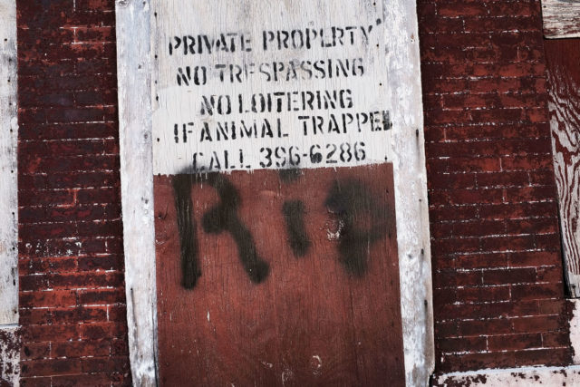 Wooden board warning that a building is private property