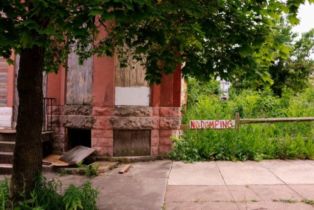 "NO DUMPING" sign attached to a wooden fence