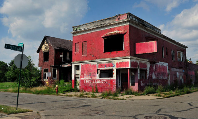 Two abandoned buildings at the corner of a street