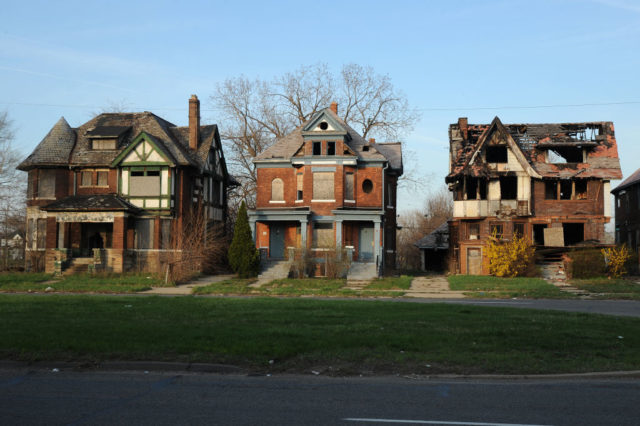 Three abandoned houses along a street in Detroit
