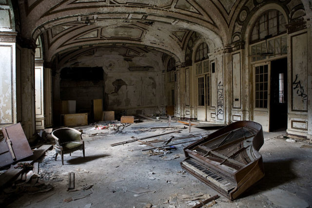 Broken piano in a dusty room within the Lee Plaza Hotel