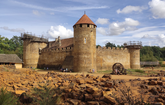 Tourists gathered around the exterior of Guédelon Castle