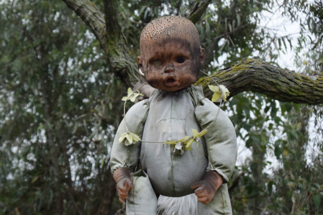 Doll with a flower crown around its neck