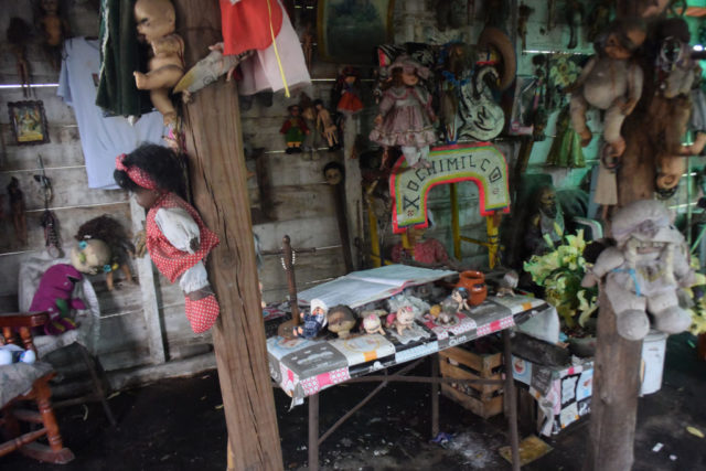 Dolls hanging above a table