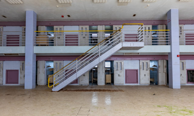 Rows of prison cells on the first and second floors of a large room