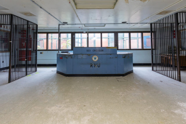Large desk surrounded by two prison cells
