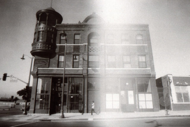 Black and white photo of the Boyle Hotel, a brick building with a small turret.