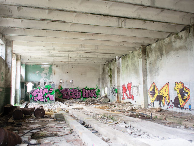 Inside an abandoned building with graffiti and crumbling brick