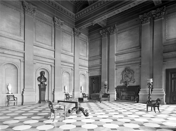 An entrance hall with tall ceilings and checkered tiling