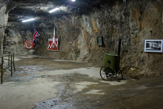 Large room constructed in the rock with flags and a 