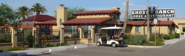 Street view of the Ghost Ranch Lodge with a white golf cart parked outside. 