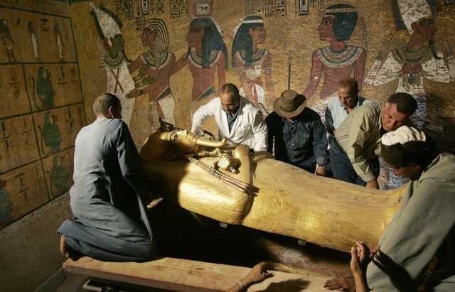Zahi Hawass and his team lifting the lid off of King Tut's sarcophagus