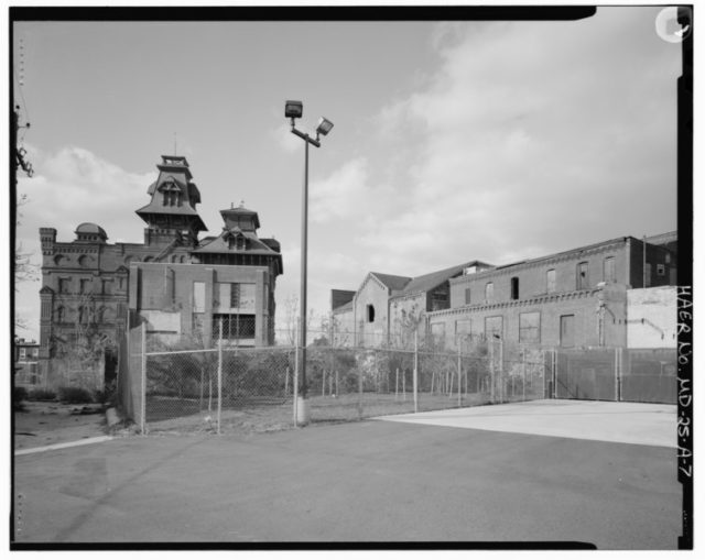 Black and white photo of the American Brewery boarded up. 
