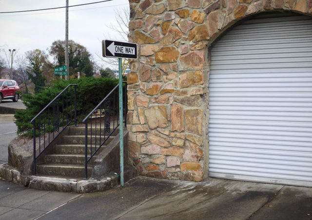 "ONE WAY" sign in front of an exterior stairway