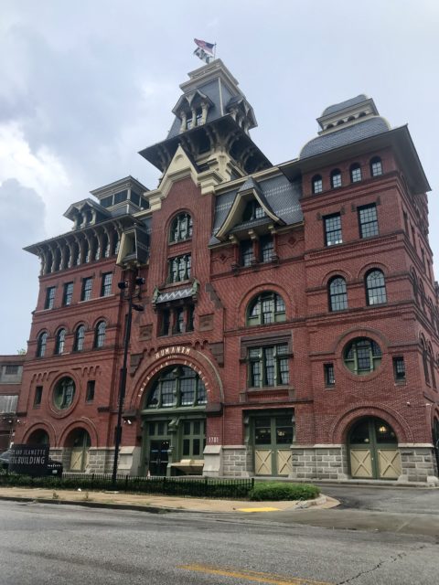 American Brewery, a large red brick building with green accents.