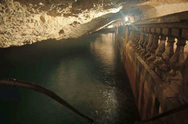 Water reservoir inside the Rock of Gibraltar with lights and a bridge. 