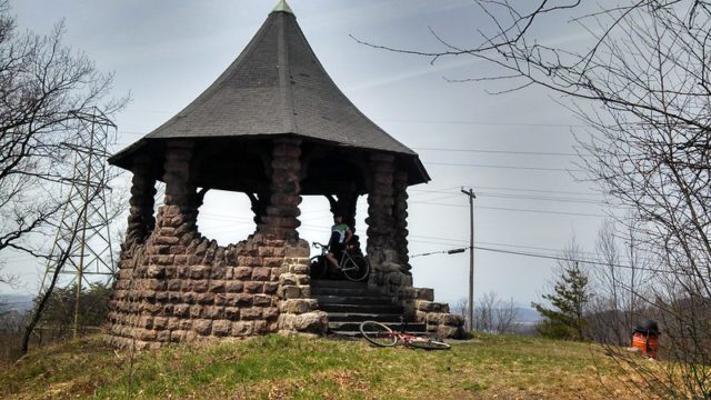 Cyclist standing in the Witch's Hat Pavilion