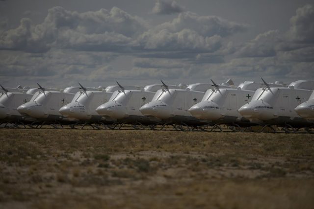 Row of Bell UH-1 Iroquois helicopters parked outside