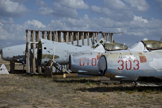 Row of damaged Mikoyan-Gurevich MiG-17s parked beside a wooden skid