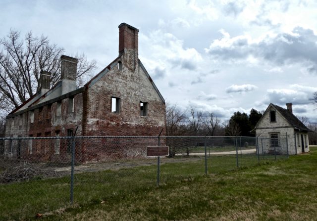 The outhouse and the remains of Marshall Hall enclosed by a fence