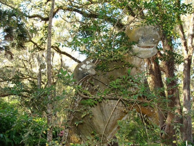 Statue of a giant ground sloth in the middle of a forest