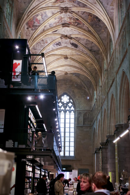 Storied bookcases inside a church chapel with domed roof