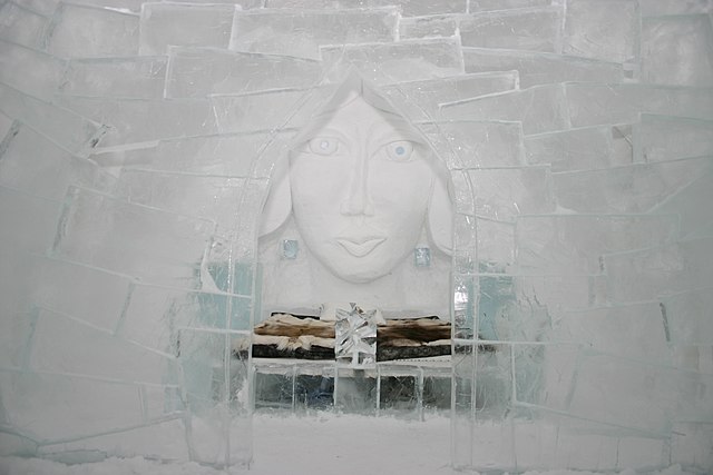 Woman's face carved into a wall of snow