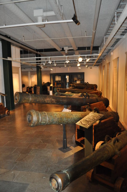 A row of cannons on display in a museum
