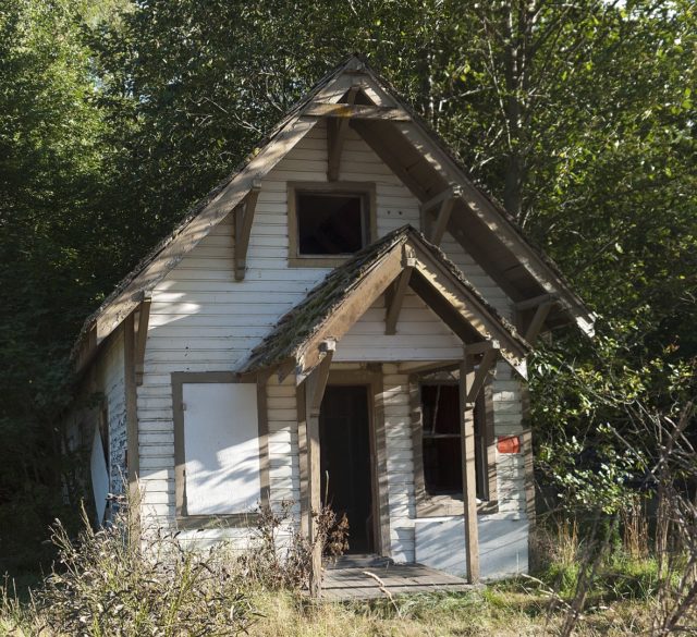 The front view of an abandoned house with no doors or windows