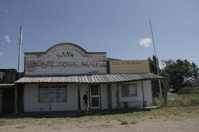 White building with faded paint that reads "Bank Ghost Town Mall."