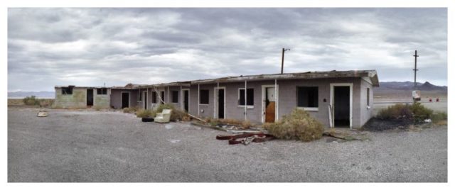 Abandoned motel with debris strewn about outside