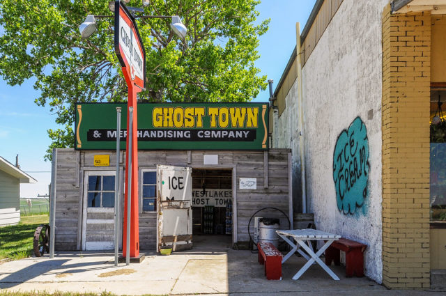 Small wooden building with a green sign that reads "Ghost Town and Merchandising Company" 