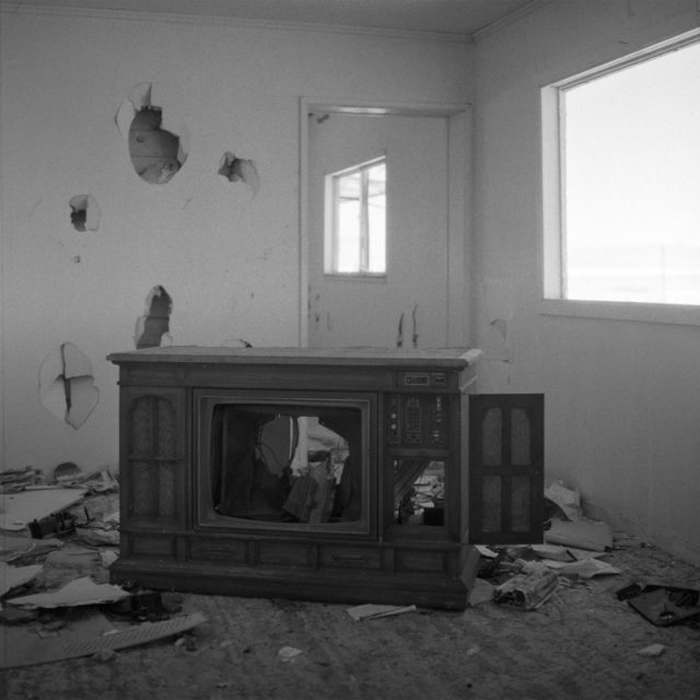 Broken television sat in the middle of a debris-strewn room