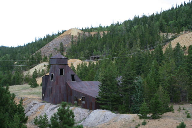 Distance shot of an old mine made of rusted metal sheets. 