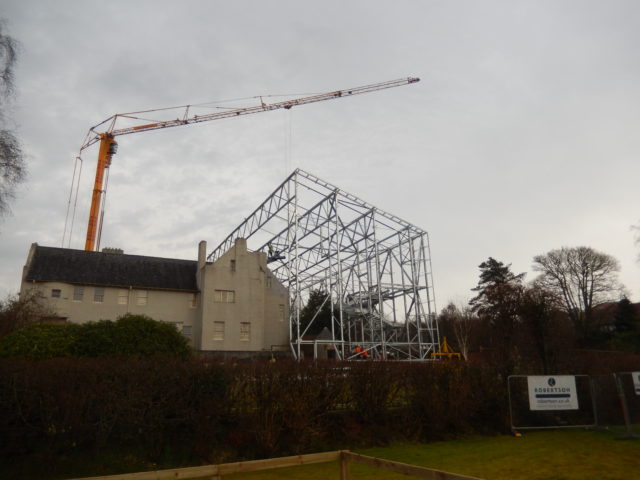 A crane working to build the metal frame of the Hill House Box