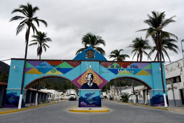 A colorful archway over two roads with the face of Nelson Mandela painted in the center