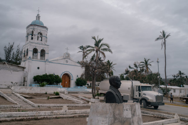 A white chapel in the background of a statue