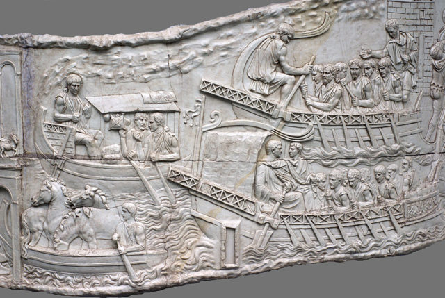 Artwork carved in stone detailing ancient Romans paddling in boats.